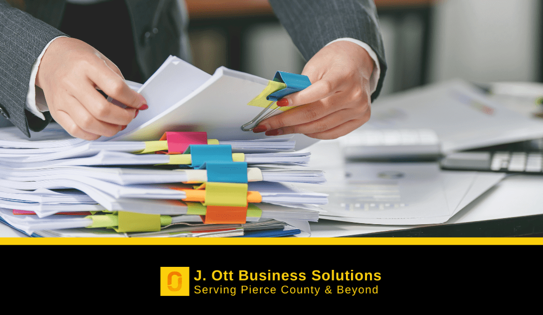 A woman's hands arrange neatly stacked and organized business records.