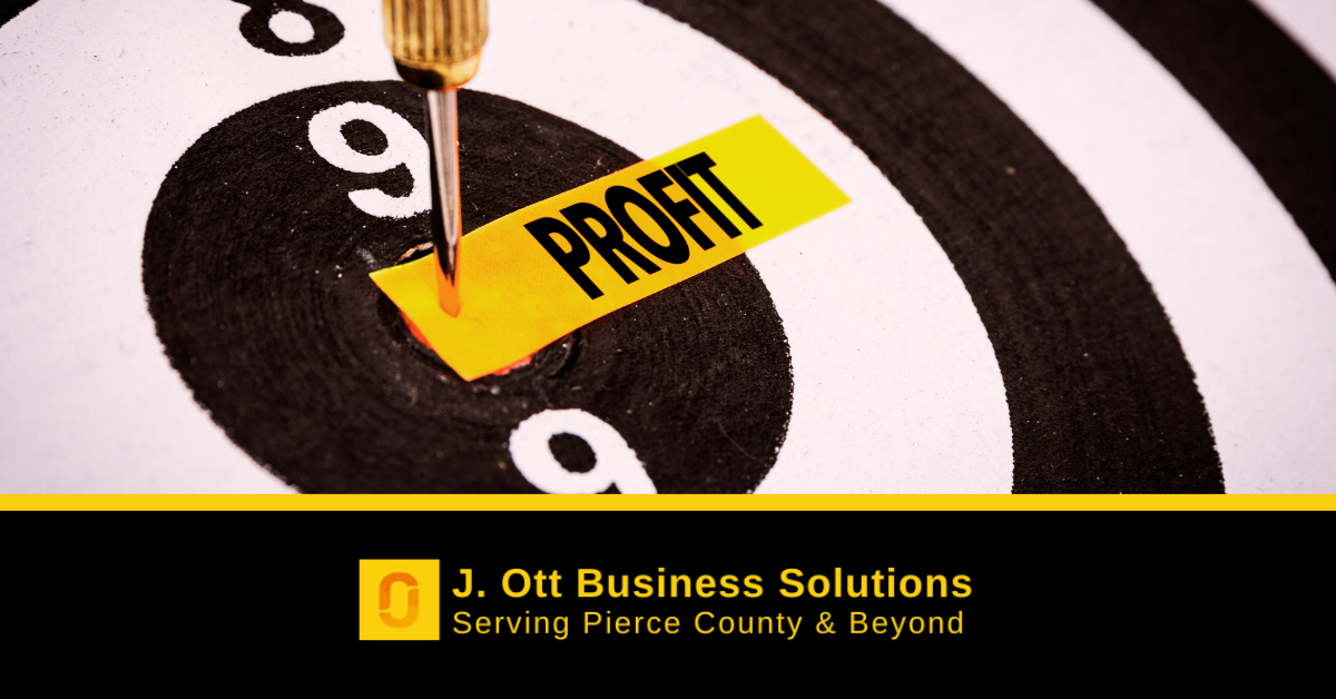 A dart board with a paper that reads: profit with a dart through it.