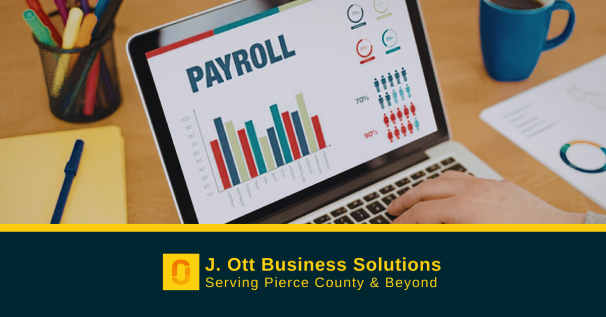 A desk with a laptop open to a a payroll report.