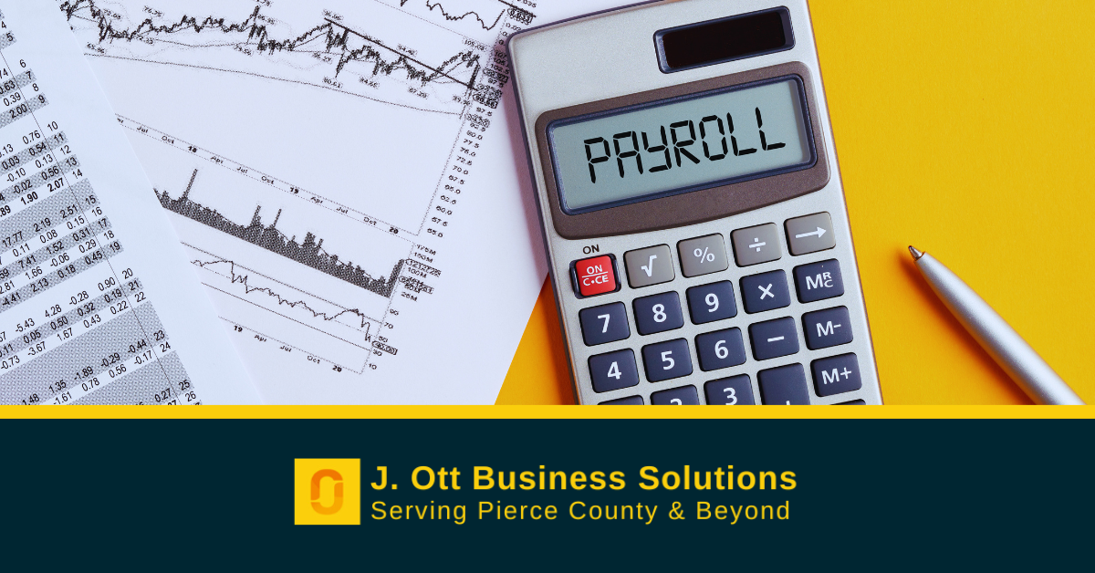 A desk with papers and a calculator that displays the word: Payroll