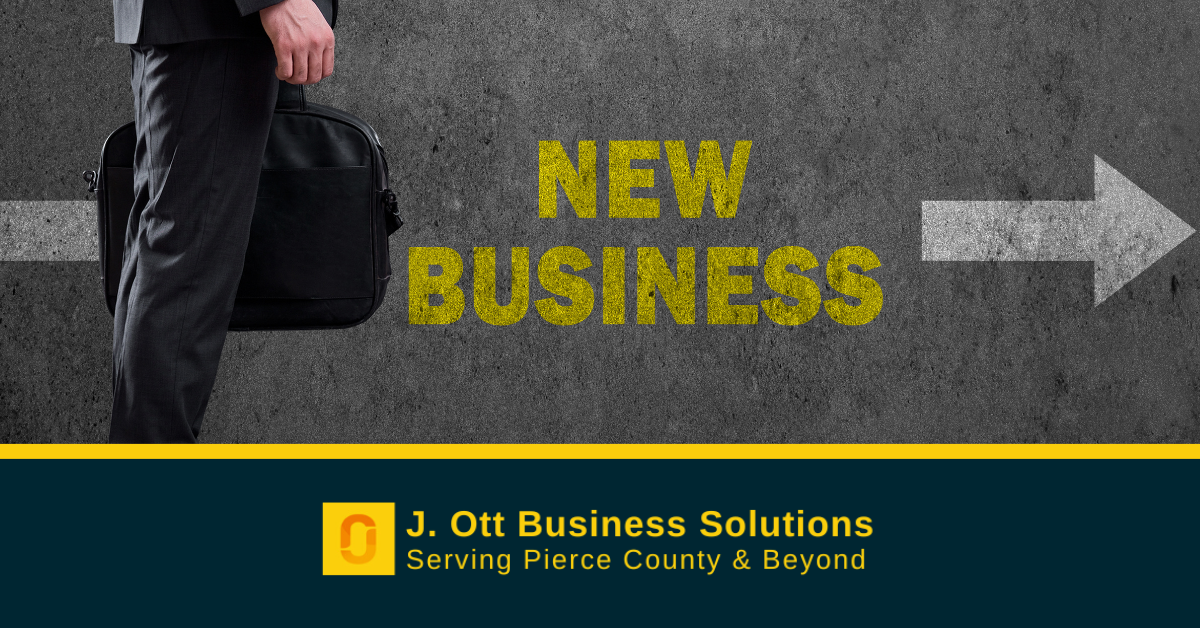 A man stands near the words New Business in chalk against a slate background.
